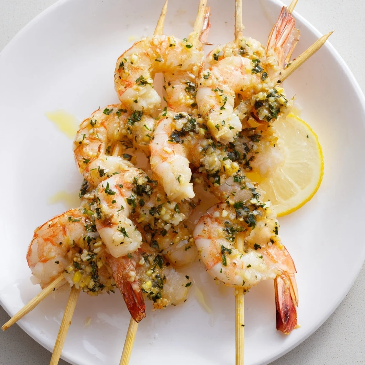 Golden-brown Lemon Garlic Shrimp Skewers are served over a bed of fluffy rice with a fresh salad.