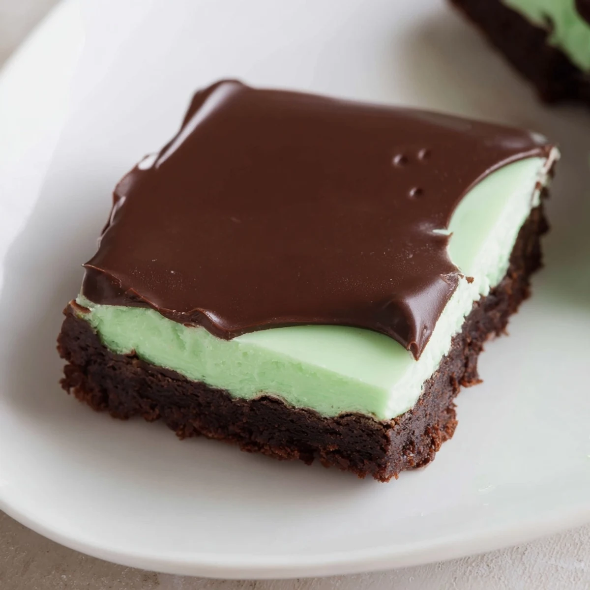Fudgy Shamrock Mint Brownies with Chocolate Ganache, topped with smooth mint frosting and glossy chocolate, ready to serve with cold milk.