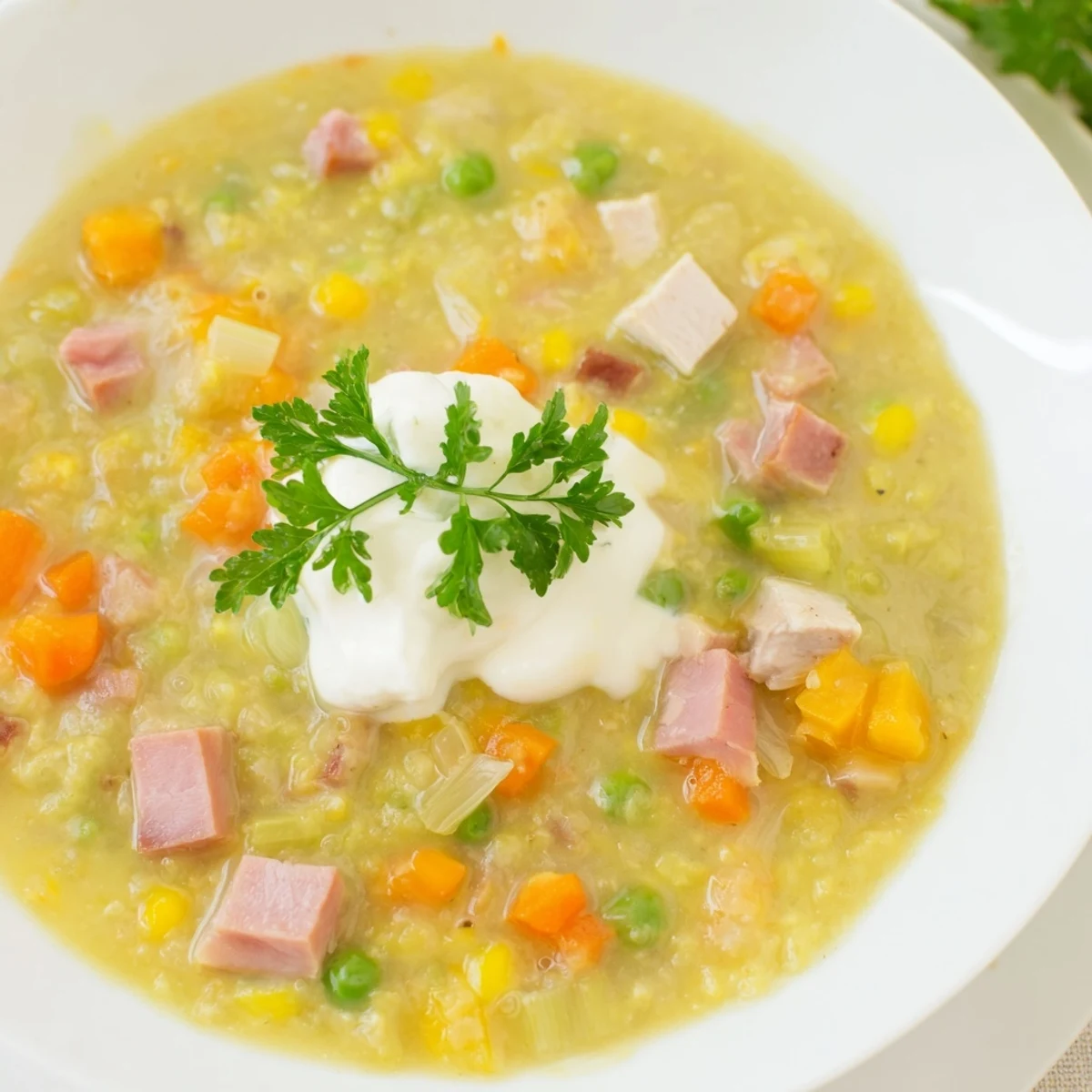 A close-up of Spring Pea Soup with Ham and Turkey, featuring vibrant green peas, diced ham, and tender turkey in a creamy broth.
