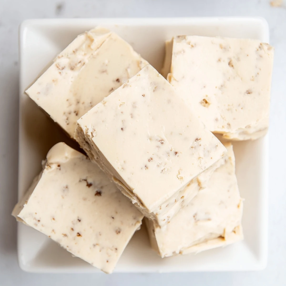 A close-up of creamy, golden Irish Cream Fudge squares with a smooth, glossy finish and rich coffee aroma.