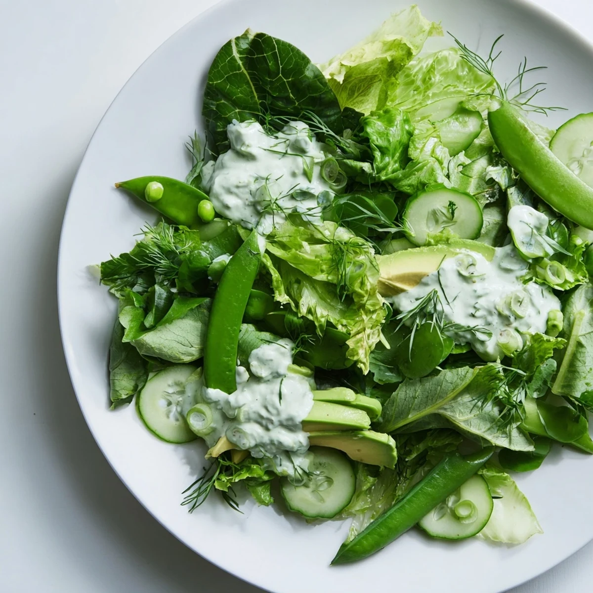 Freshly tossed Green Salad with Green Goddess Dressing featuring snap peas and green onions for a bright, refreshing bite.