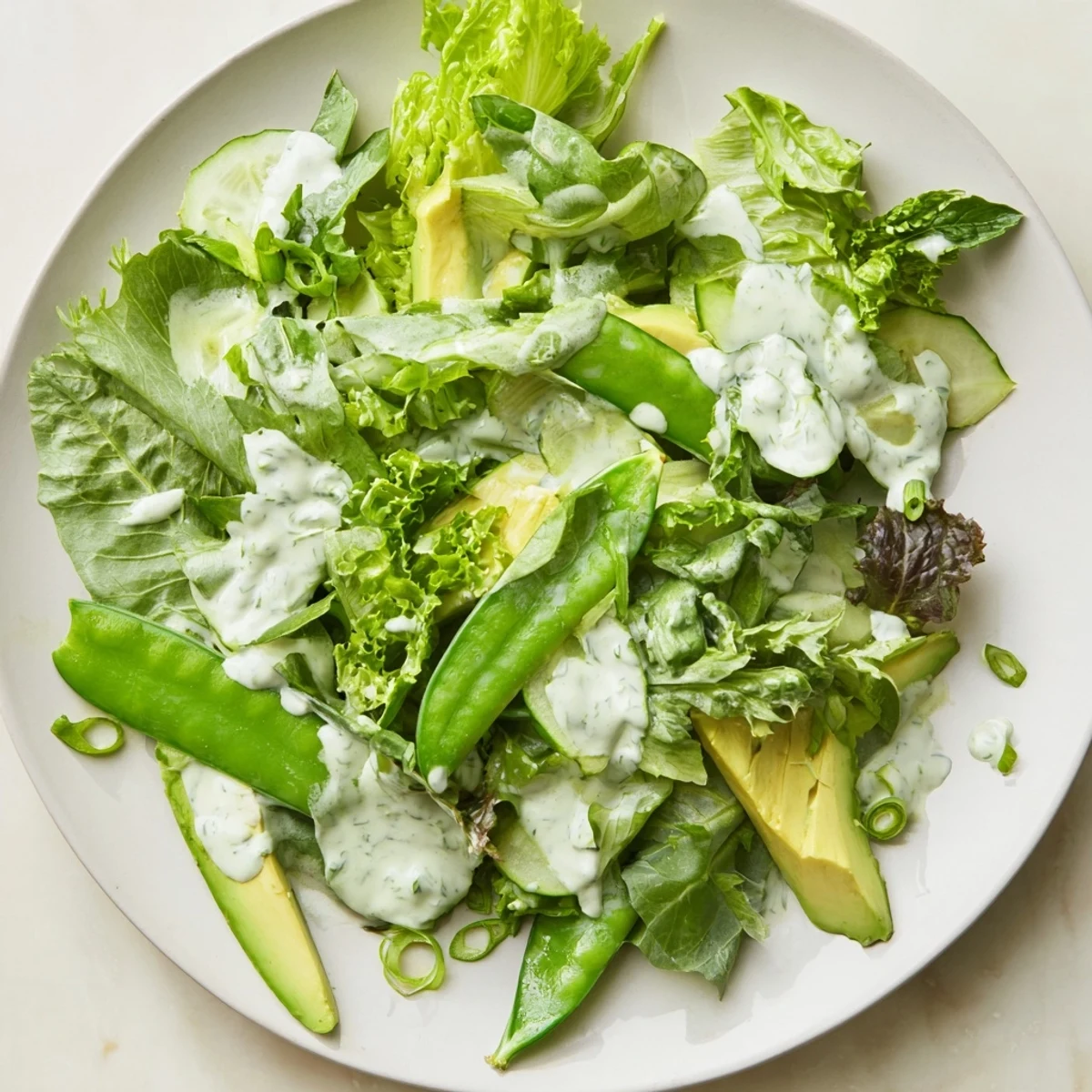 A close-up of a generous serving bowl of Green Salad with Green Goddess Dressing, perfect as a light vegetarian side.