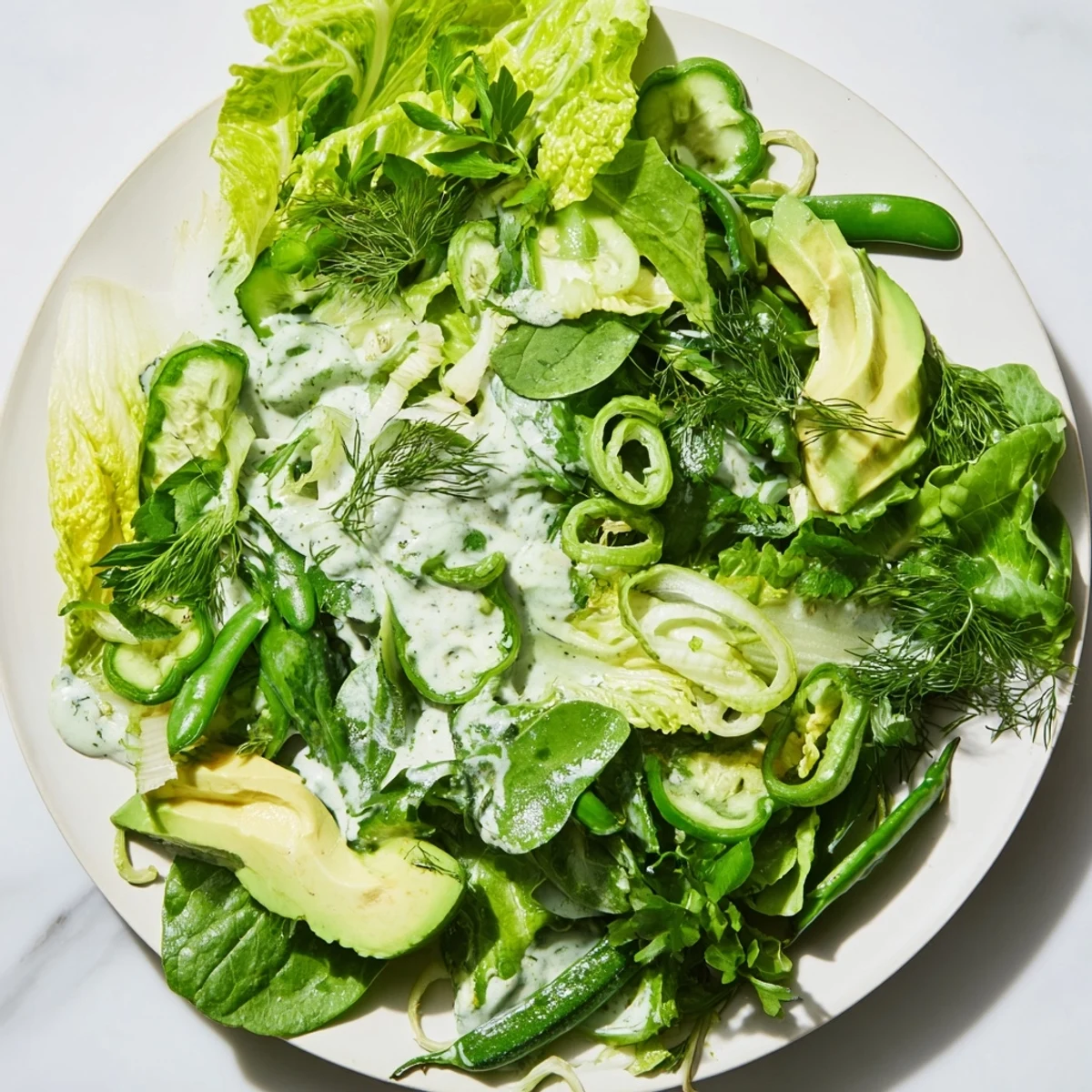 A close-up of Green Salad with Green Goddess Dressing, showcasing fresh herbs and scallions tossed with a creamy green dressing.