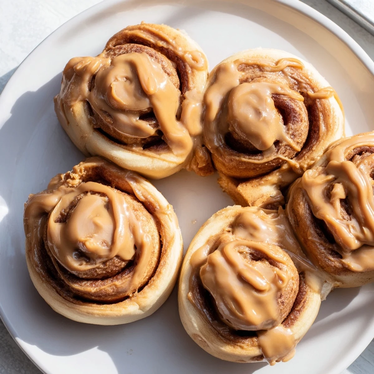 Warm, golden Soft and Gooey Biscoff Cinnamon Rolls fresh from the oven, drizzled with creamy cookie butter glaze.
