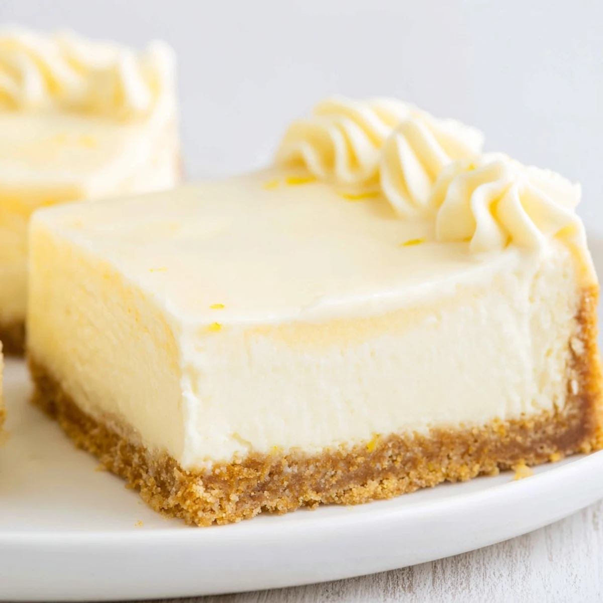 Freshly baked Rich Greek Yogurt Cheesecake slice showing its creamy, tangy texture and graham cracker crust.