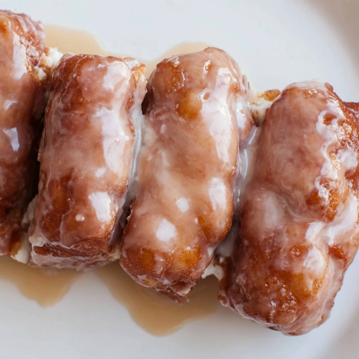 Golden-brown Maple Donut Bars cooling on a wire rack with a glossy, sweet maple glaze dripping down the sides.