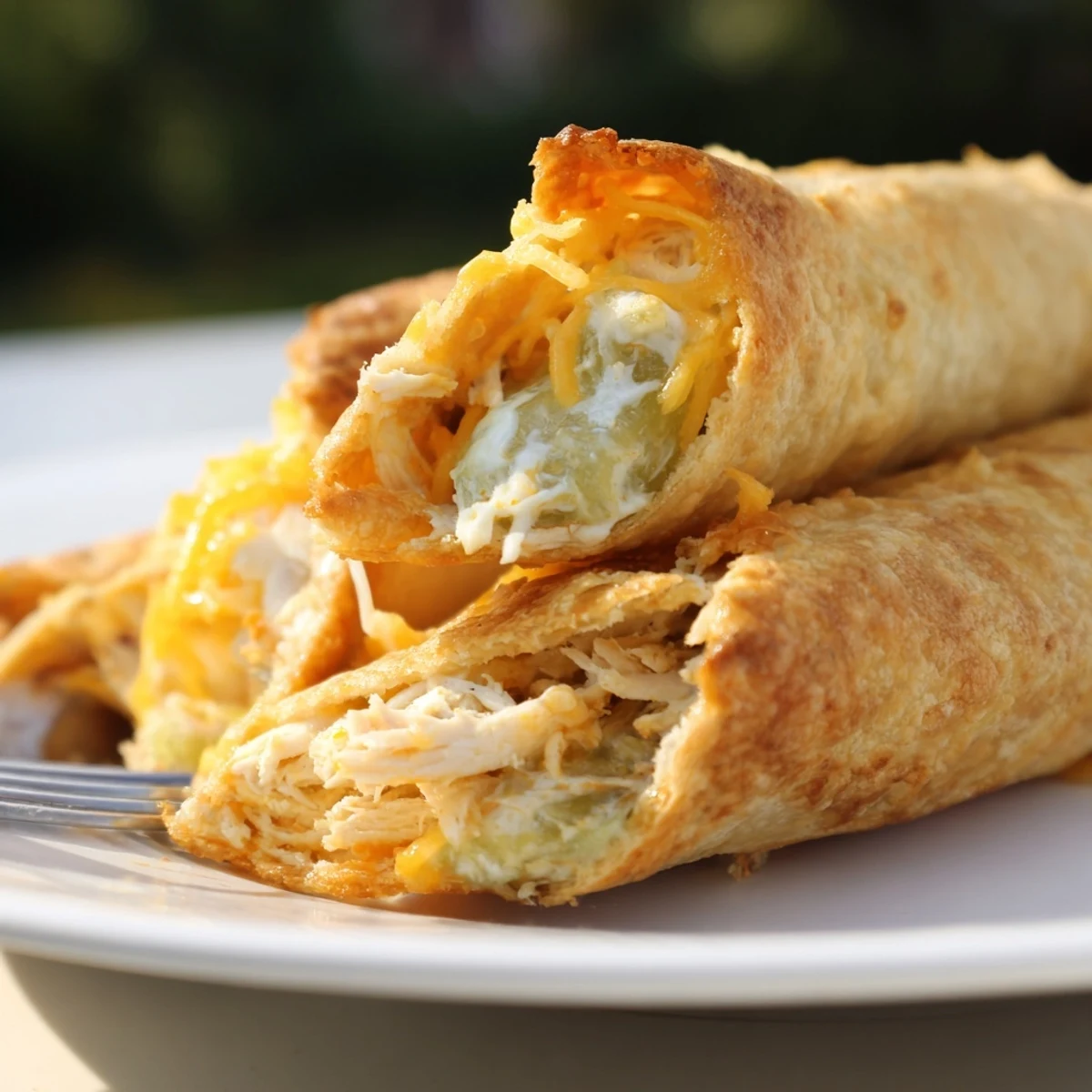 Freshly baked Dill Pickle Ranch Chicken Taquitos, filled with creamy ranch, chopped dill pickles, and melted cheddar cheese.