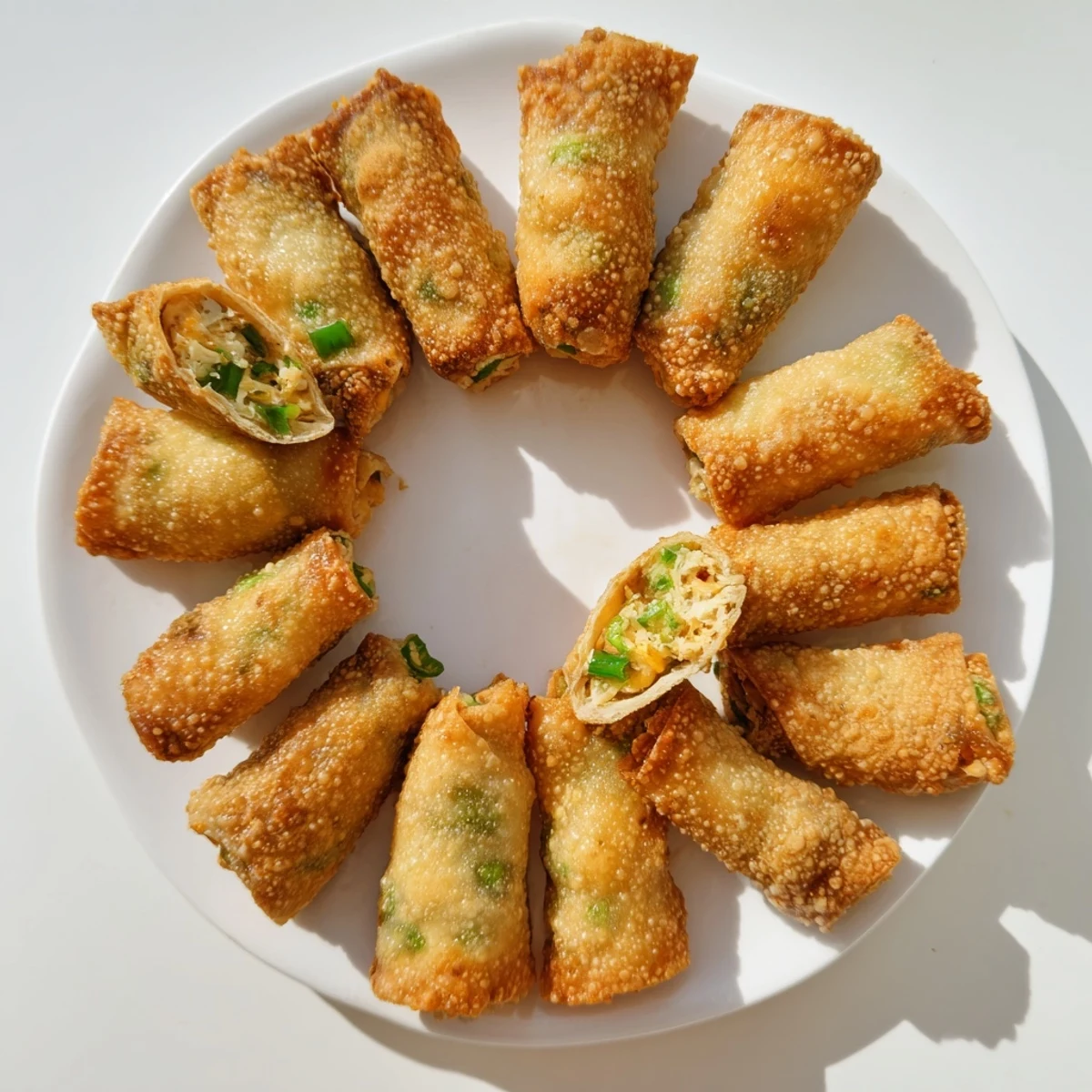 Overhead view of crispy Mini Jalapeño Popper Egg Rolls, showcasing their crunchy texture and golden, fried exterior on parchment.
