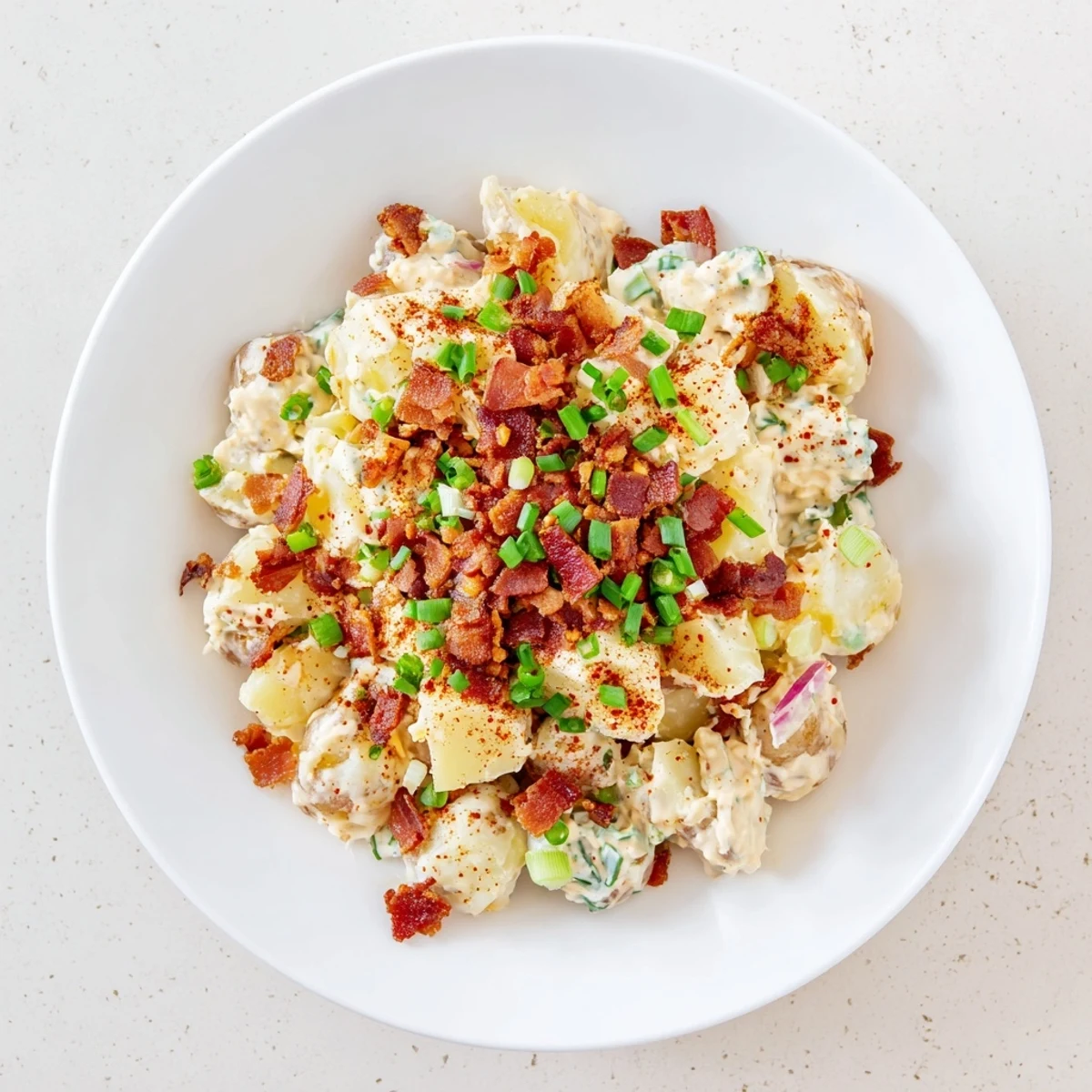 Golden potatoes and crumbled bacon in Steakhouse Potato Salad, with a tangy Dijon dressing in a rustic serving dish.