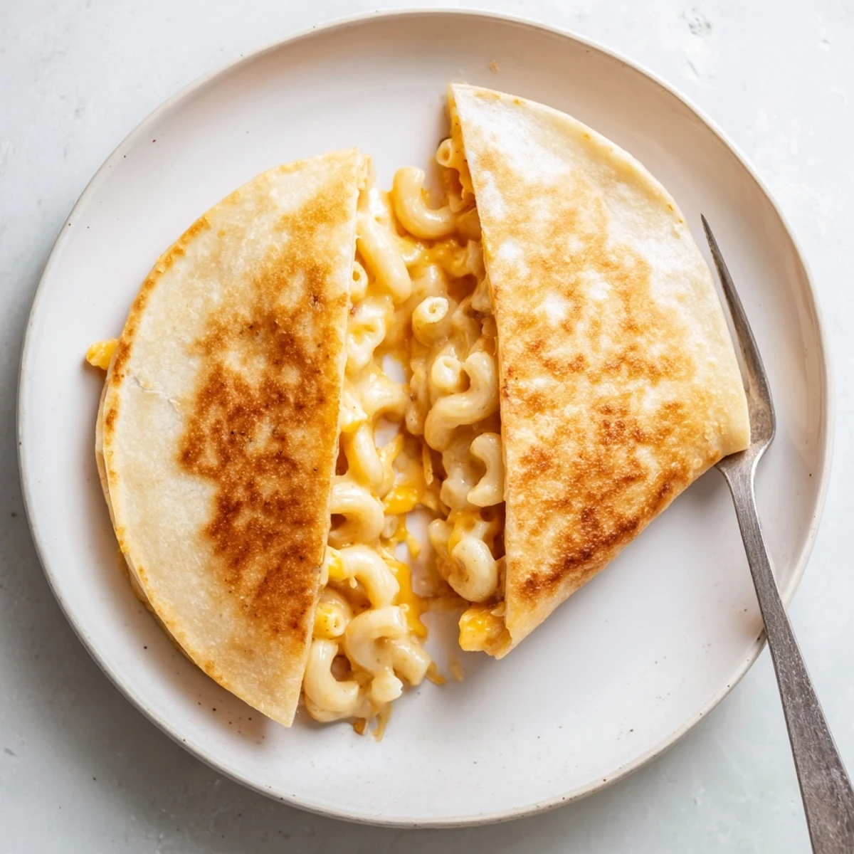 Crispy flour tortilla sandwiching homemade cheddar macaroni cheese melted to gooey perfection