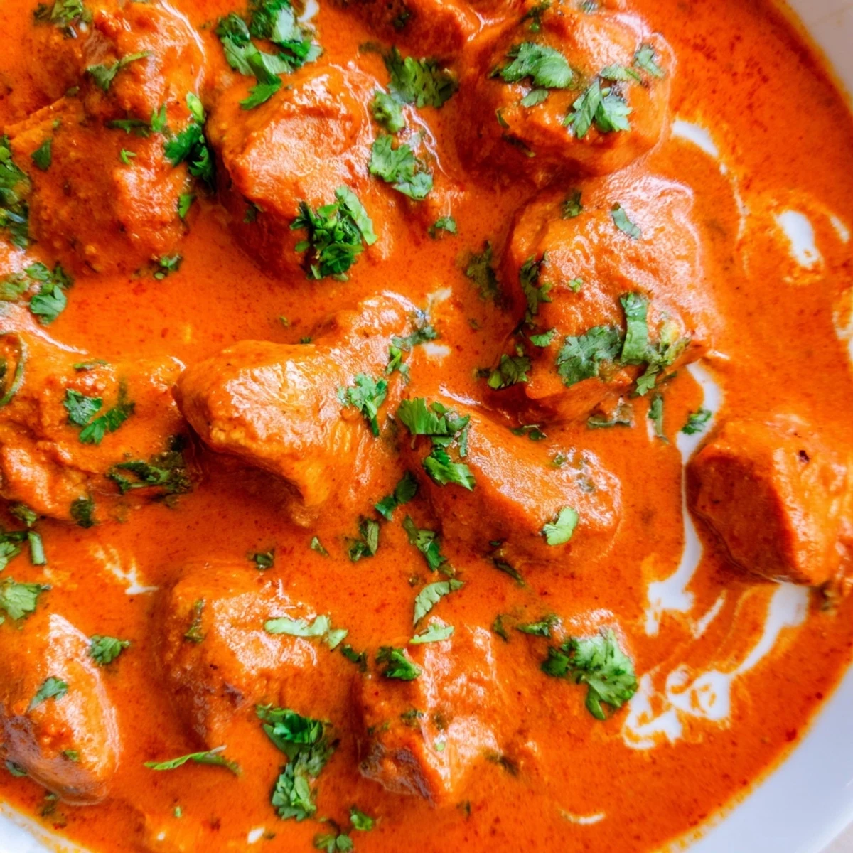 Golden butter chicken served steaming hot in a bowl alongside fluffy basmati rice and soft garlic naan bread