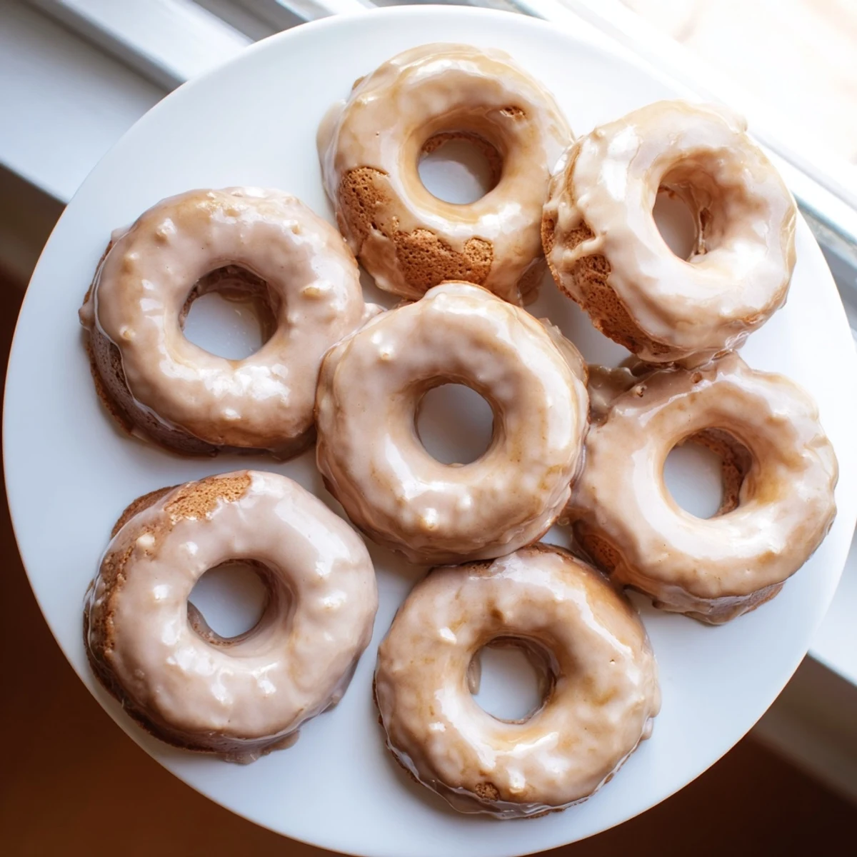 Soft gluten-free maple pumpkin mochi donuts topped with sweet dripping maple icing glaze