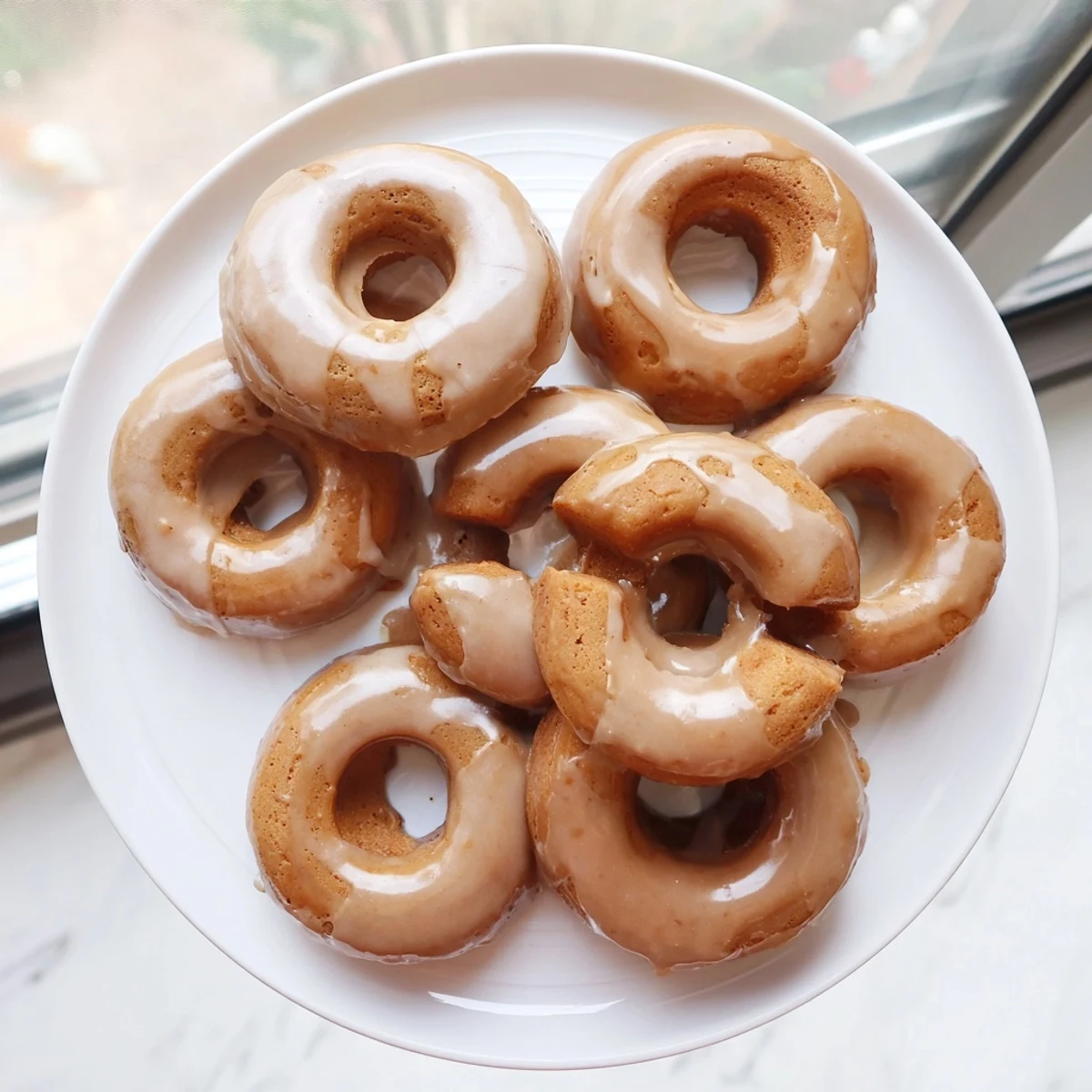 Baked pumpkin mochi donuts drizzled with rich maple syrup glaze for fall desserts