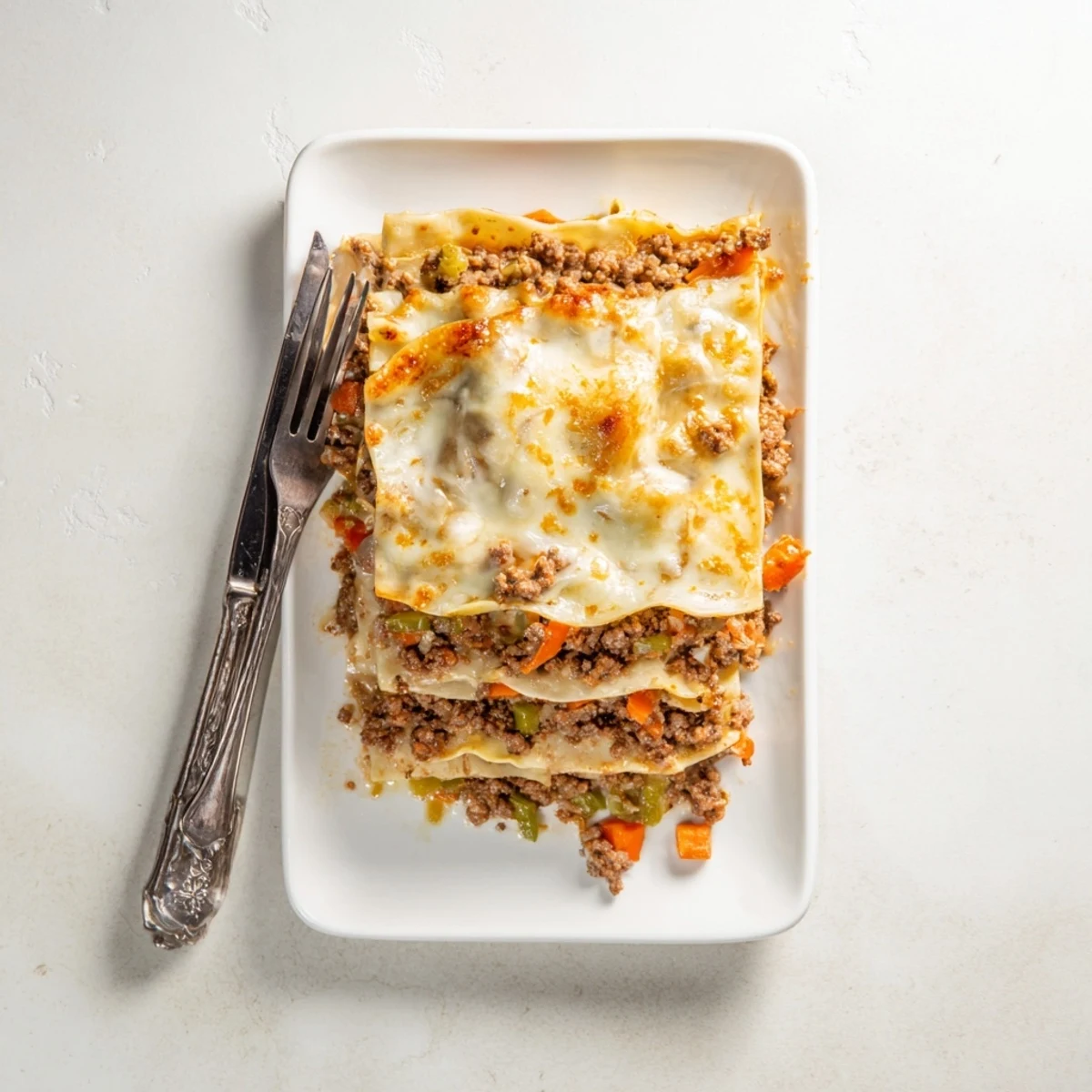 Golden bubbling classic beef lasagne with layers of rich meat ragù and melted mozzarella cheese