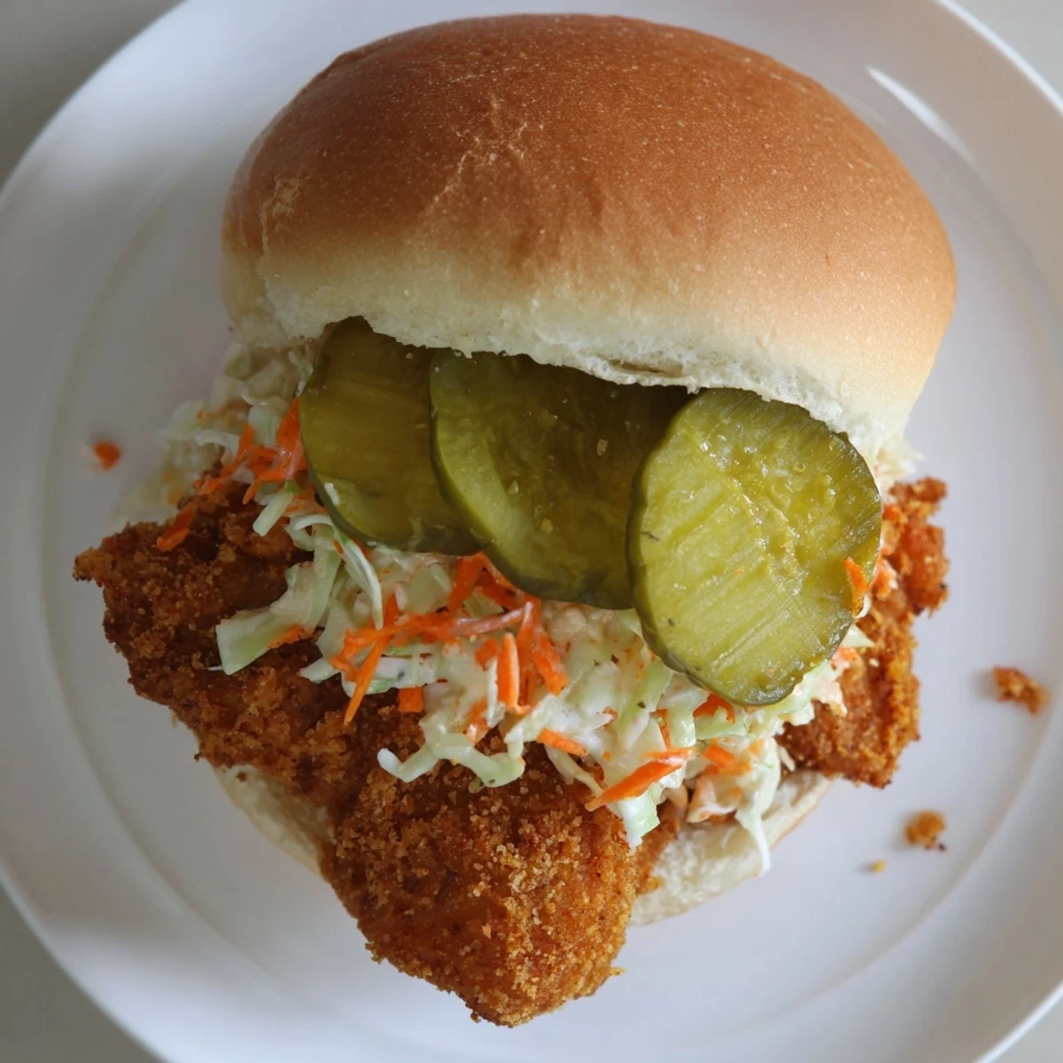 Golden Southern fried chicken burgers piled high with tangy slaw and crisp dill pickles on toasted buns