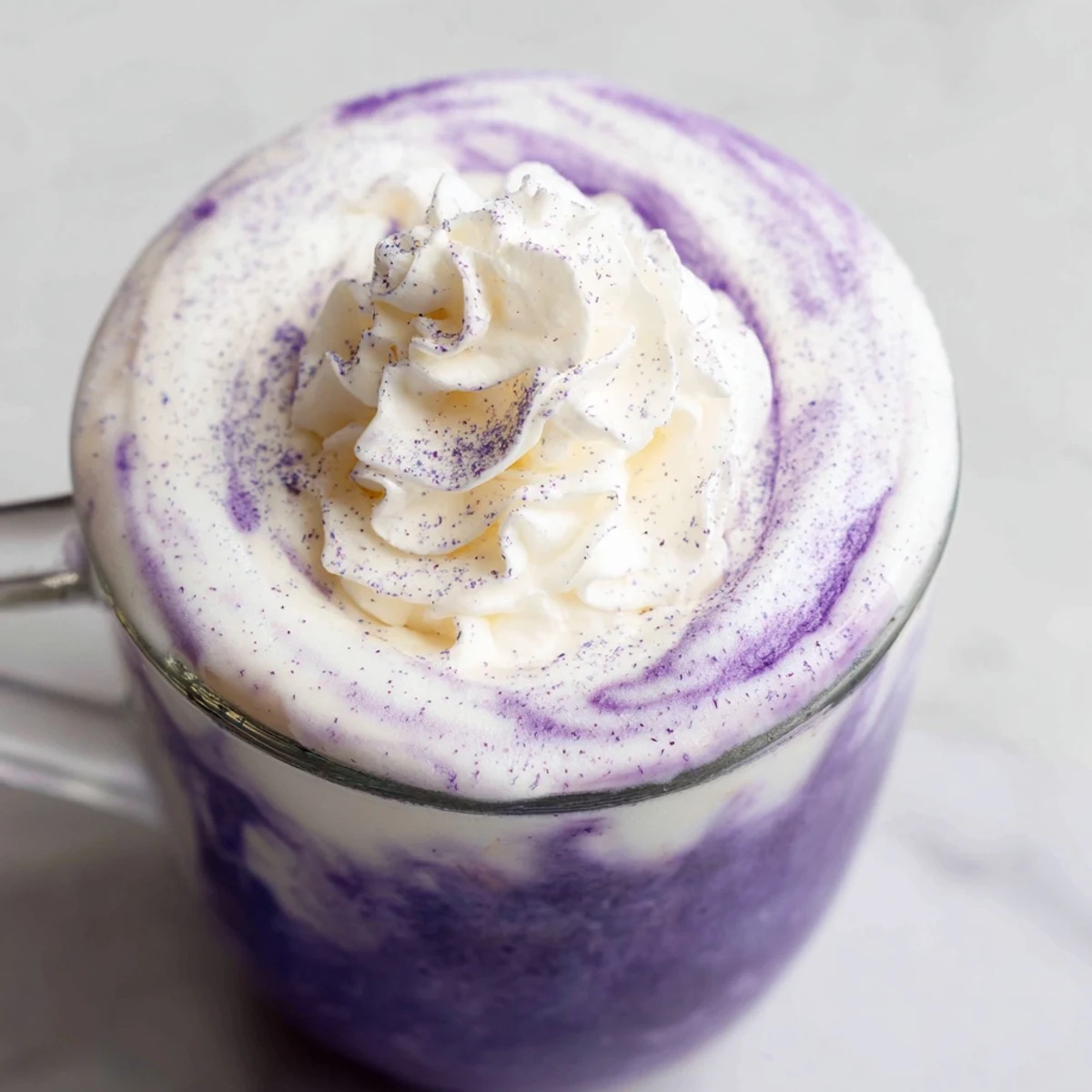 Iced ube latte showcasing vibrant purple swirls in clear glass with espresso