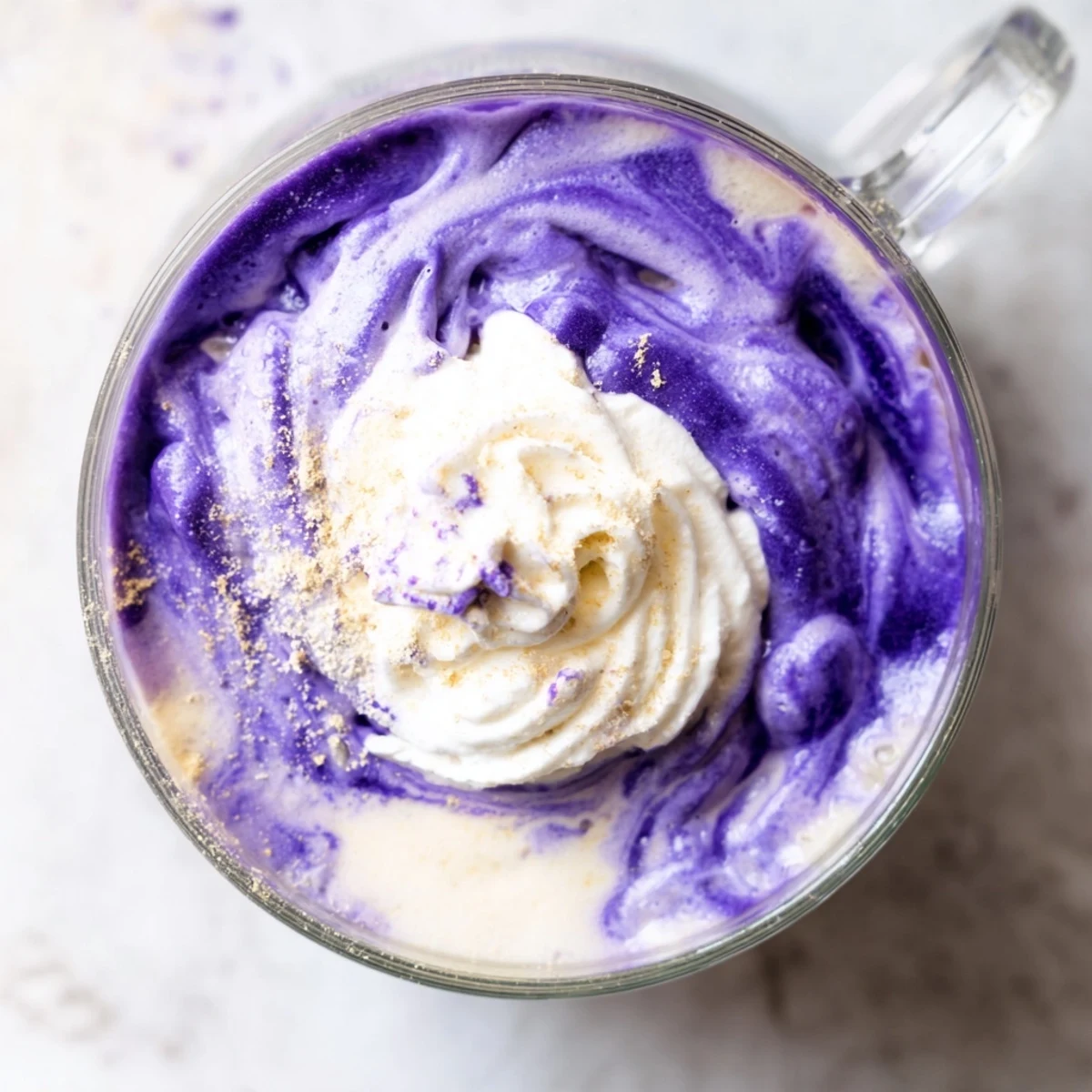 Creamy purple ube latte topped with whipped cream and purple yam flakes