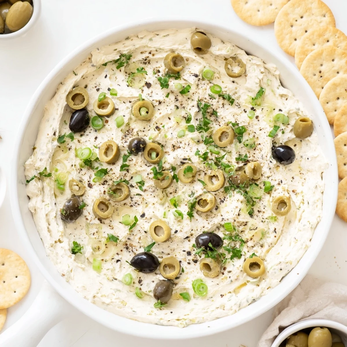 Tangy cream cheese olive dip with green and black olives garnished with fresh parsley
