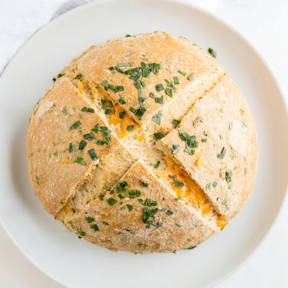 Warm rustic cheddar and herb soda bread brushed with melted butter, cross-cut top showing golden baked edges and herb flecks