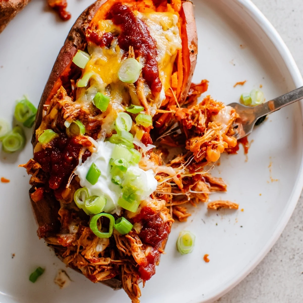 Golden roasted sweet potatoes overflowing with saucy BBQ chicken and melted cheddar cheese