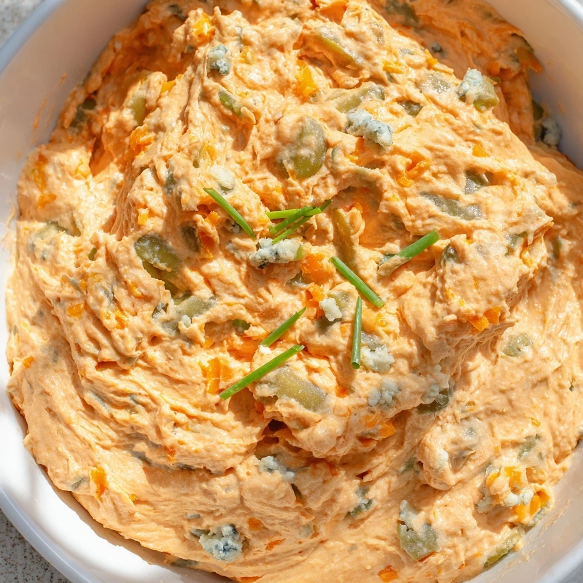 Creamy buffalo pickle dip served in a bowl with crispy chips for game day snacking