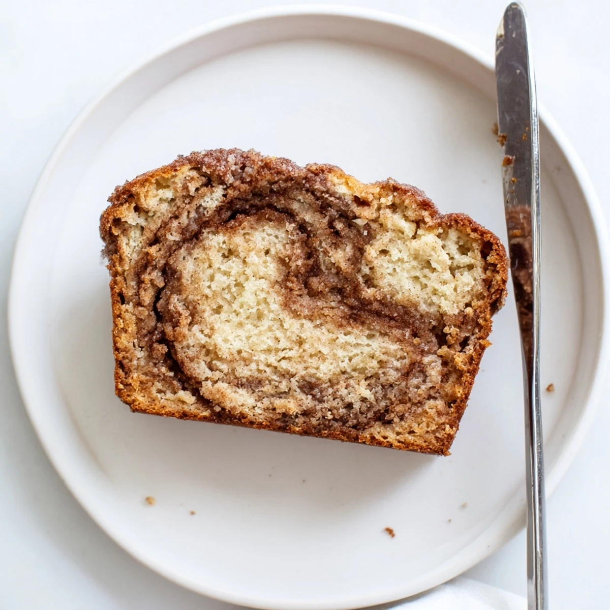 Moist snickerdoodle banana bread loaf topped with crackly cinnamon sugar