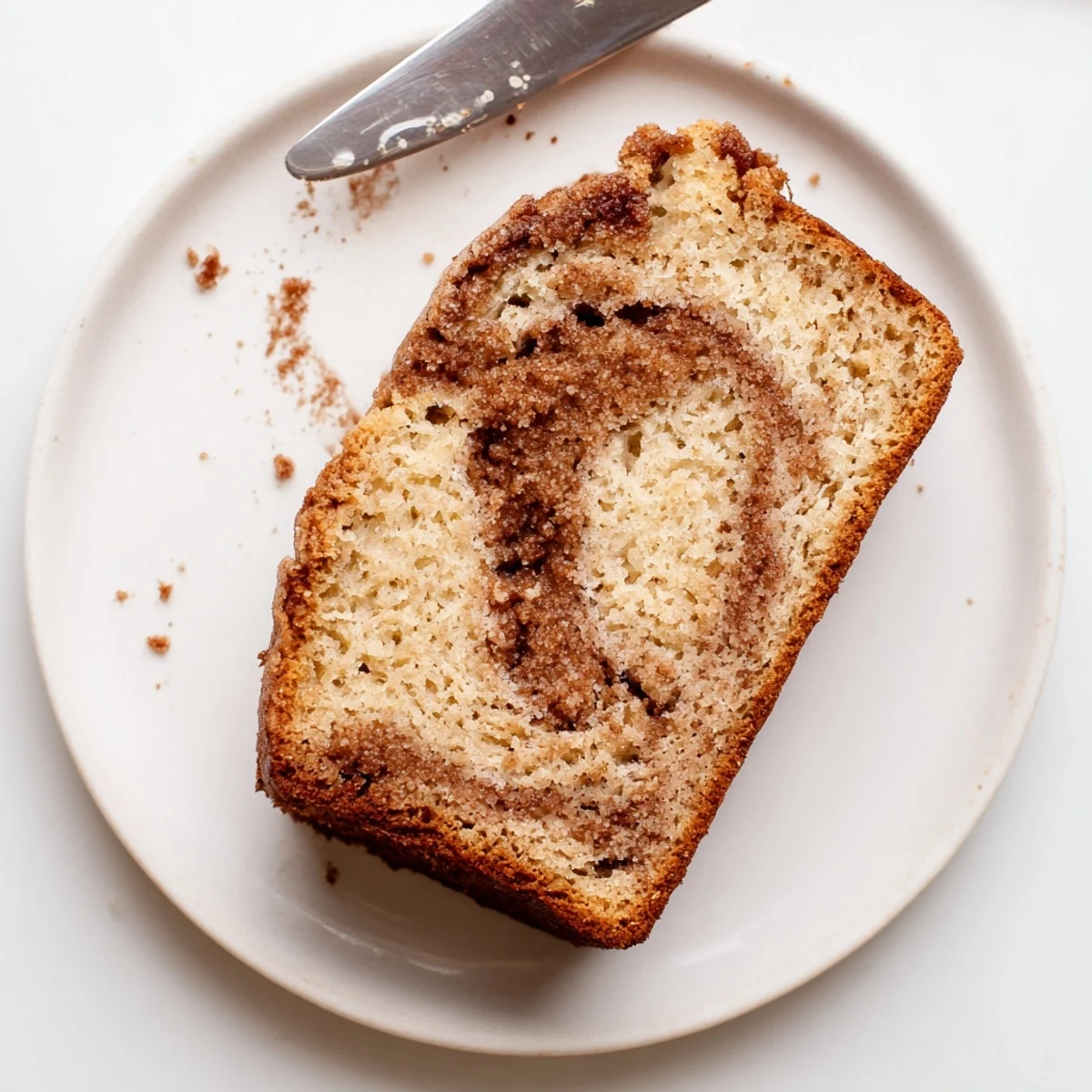 Golden snickerdoodle banana bread slice with a warm cinnamon-sugar swirl