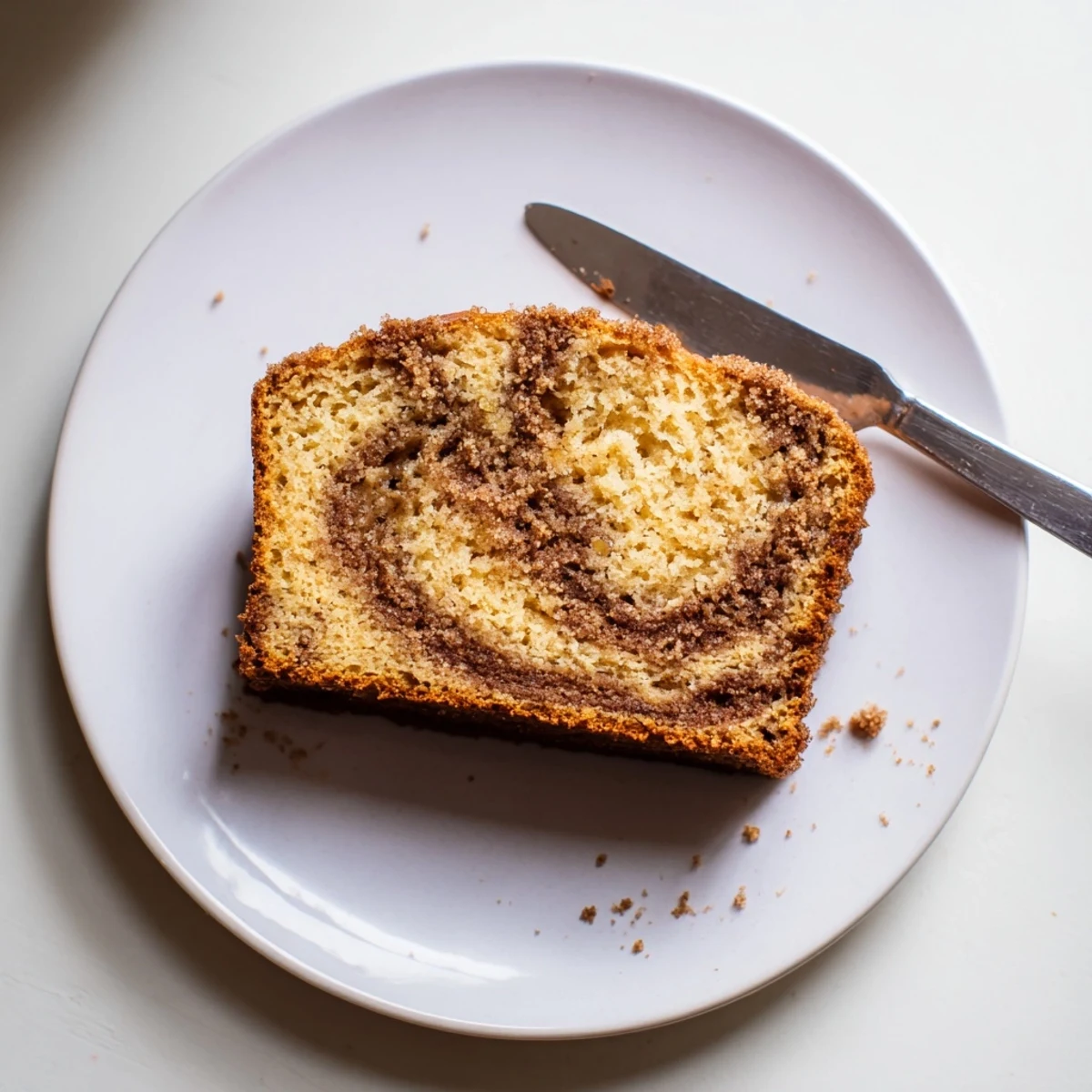 Thick slice of snickerdoodle banana bread served warm with melted butter