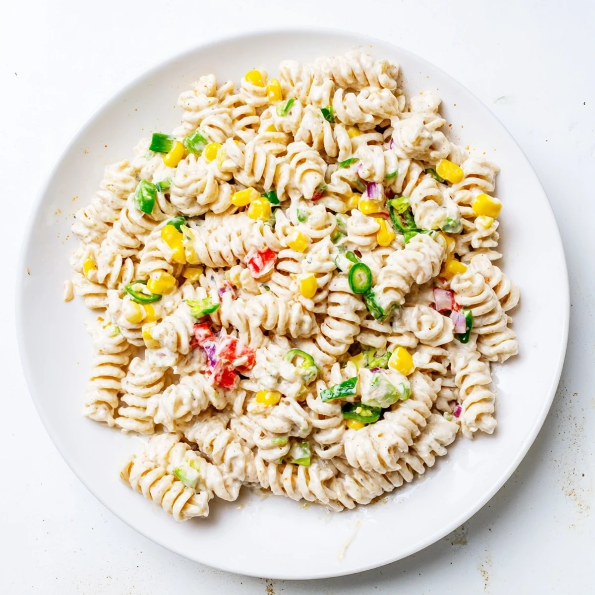 Juicy Street Corn Pasta Salad with charred corn, creamy dressing, lime wedges