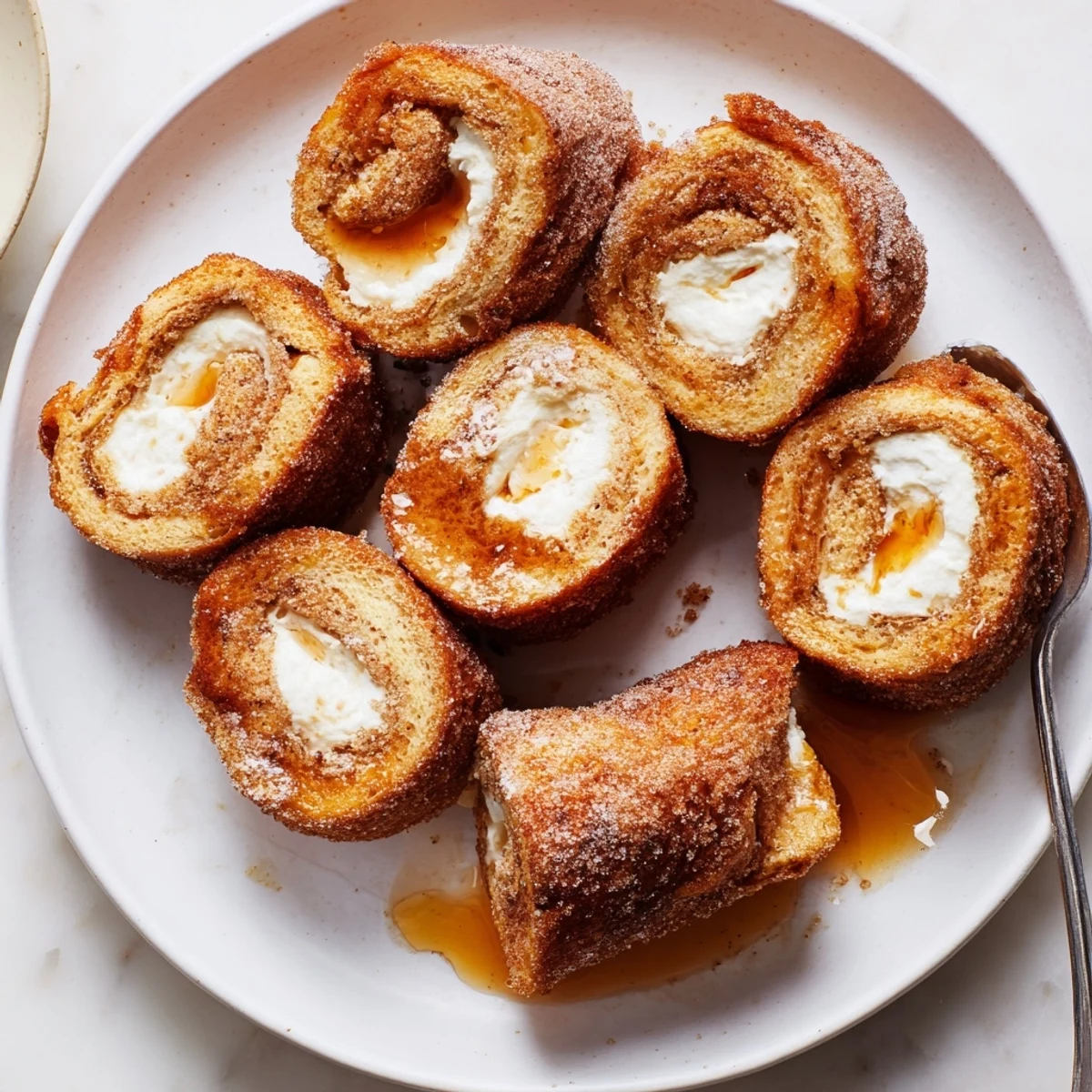 Handheld Cinnamon Roll French Toast Roll Ups filled with sweet cream cheese