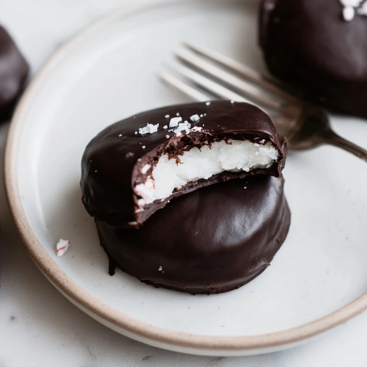 Homemade Peppermint Patties chilled on a baking sheet, dusted with powdered sugar