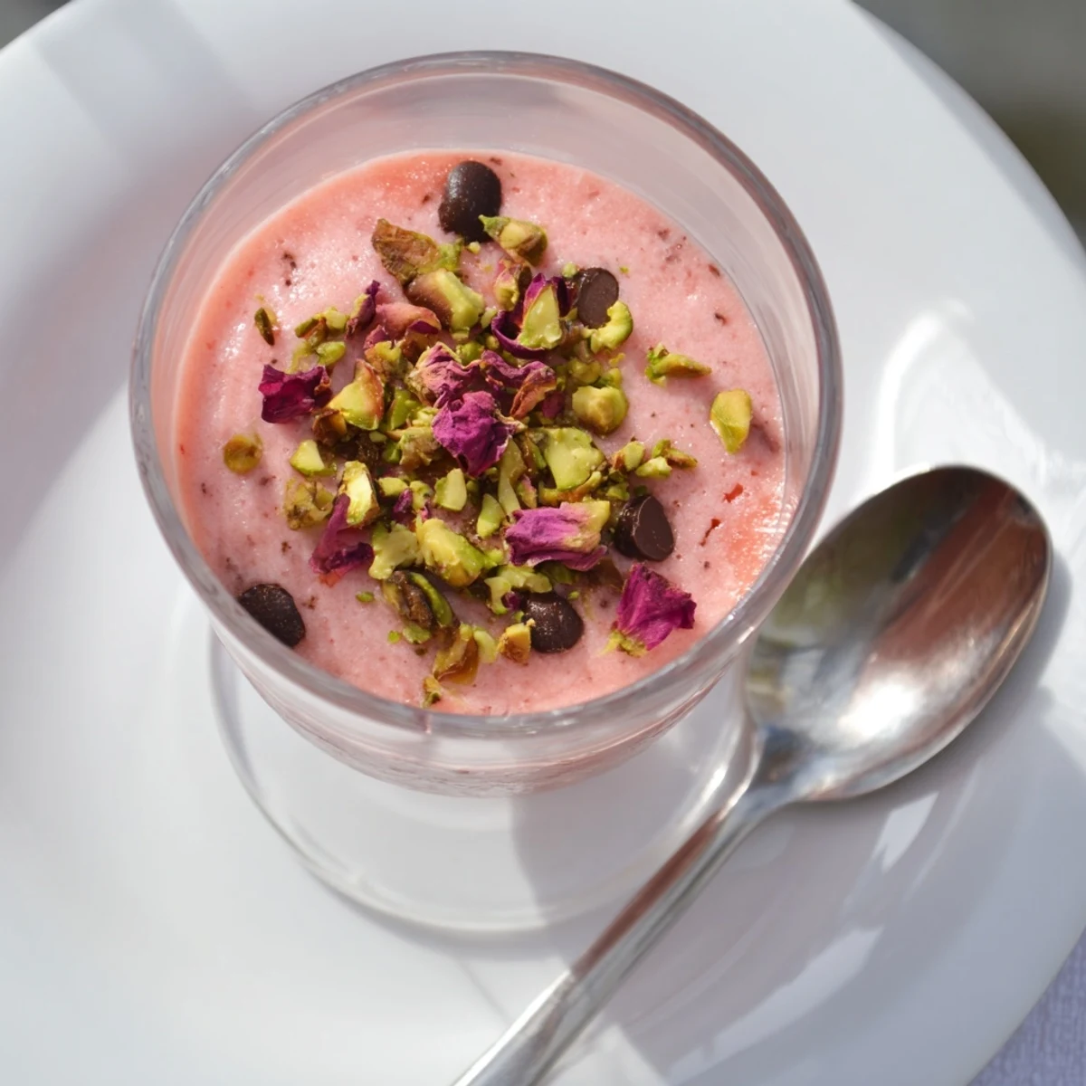 Sicilian watermelon pudding garnished with chopped pistachios and dark chocolate chips in clear glass serving dishes