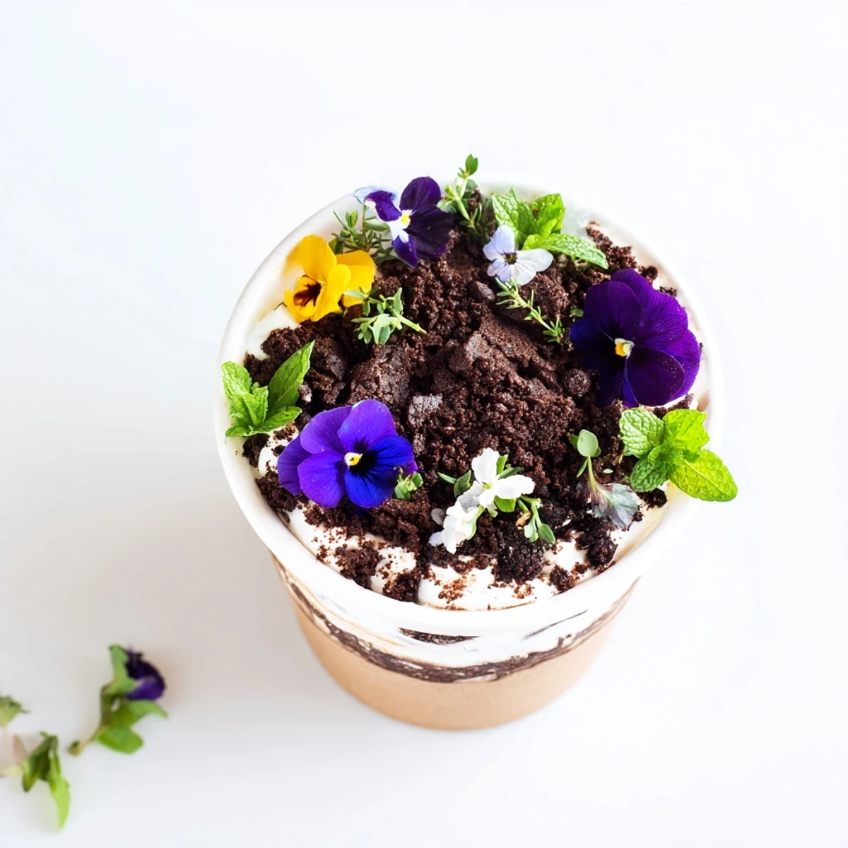 Whimsical edible potted floral garden dessert featuring chocolate cake layered with vanilla cream and topped with chocolate cookie soil