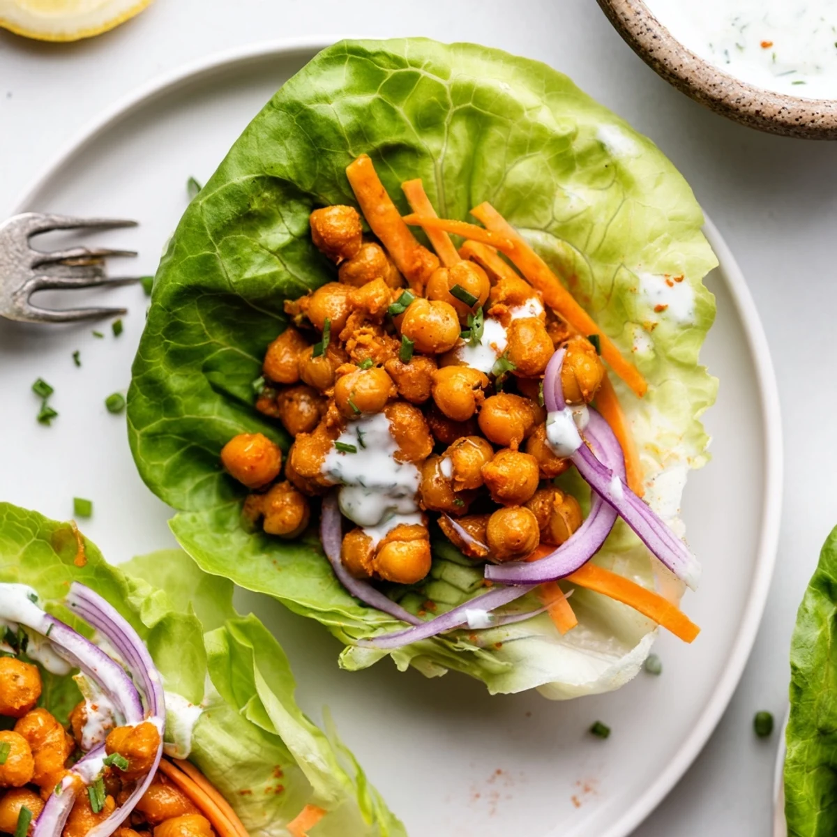 Warm Buffalo Chickpea Lettuce Wraps with crunchy celery, shredded carrots, creamy ranch