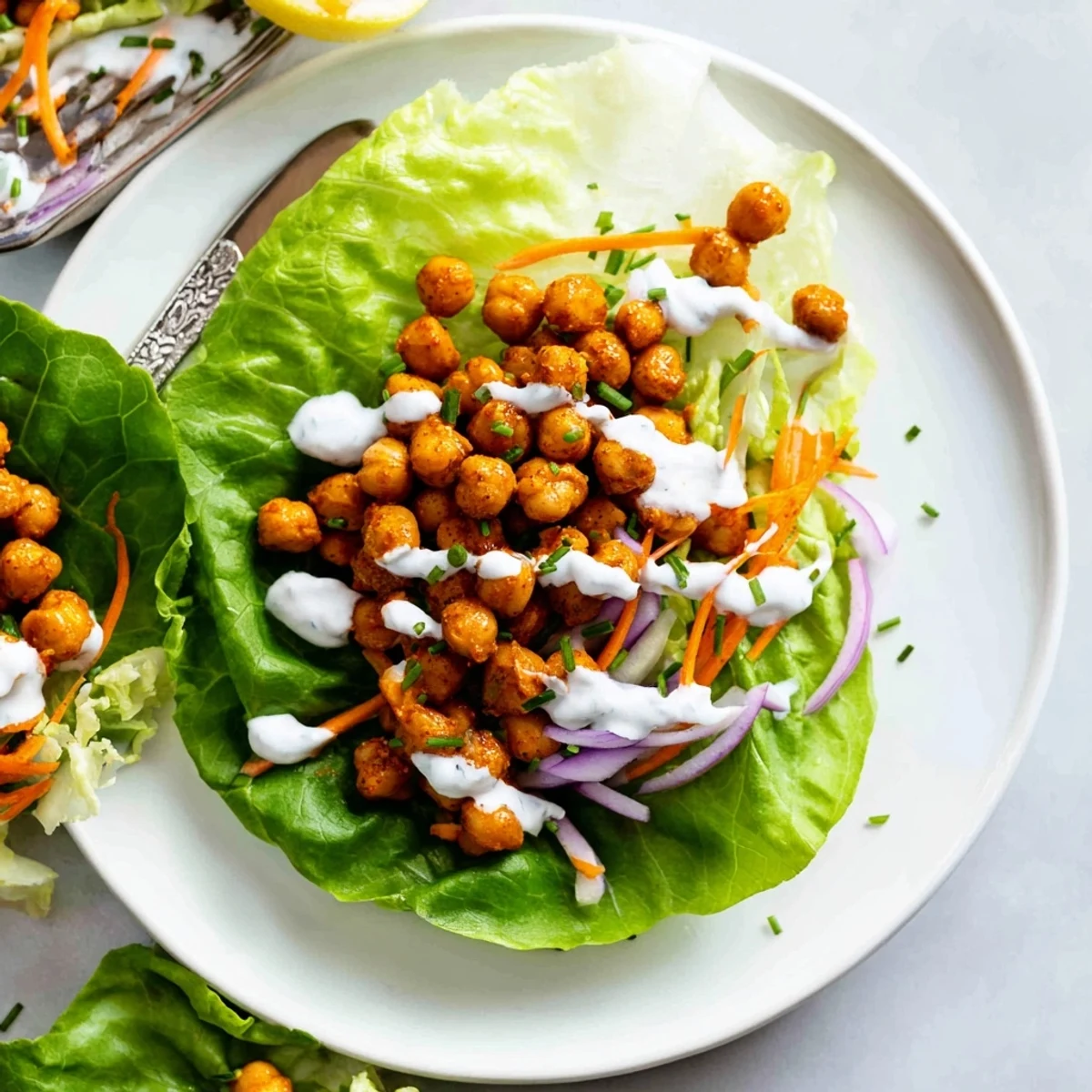 Buffalo Chickpea Lettuce Wraps piled on platter, spicy chickpeas and crisp lettuce