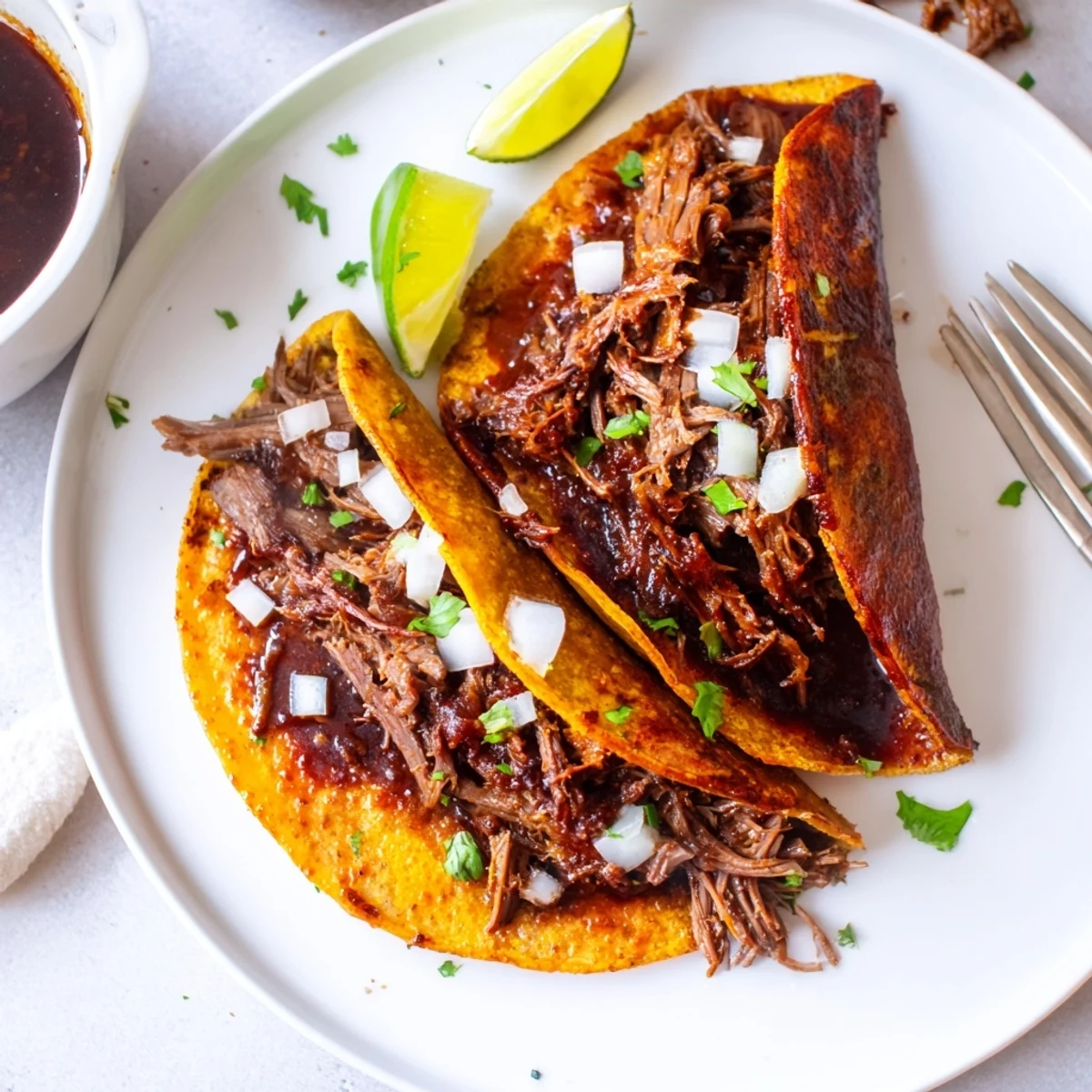 Plate of Super Crispy Birria Tacos steaming, shredded beef oozing juicy consommé