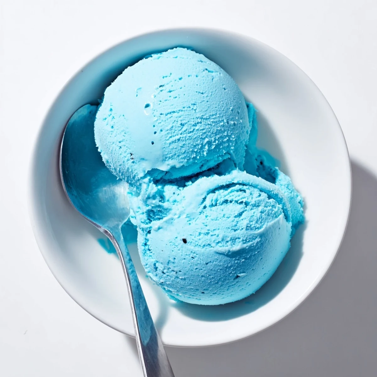 Creamy blue moon ice cream scooped into a crispy waffle cone with colorful sprinkles