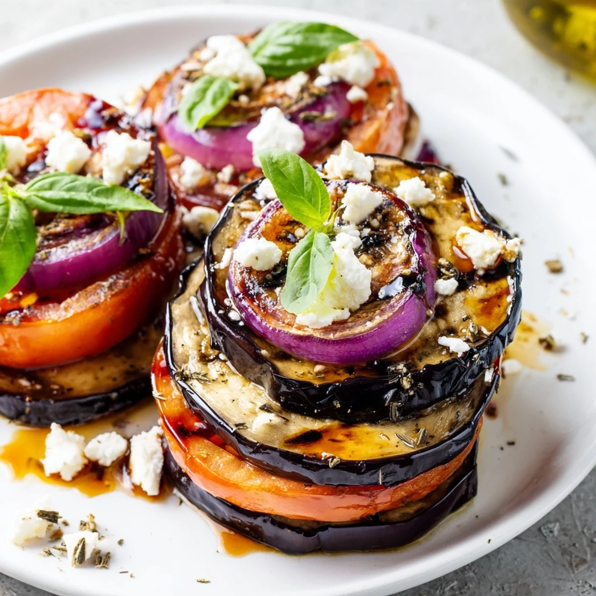 Golden charred eggplant and ripe grilled tomato eggplant drizzled with balsamic marinade on a summer plate
