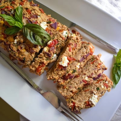 Slices of juicy Mediterranean turkey meatloaf featuring sun-dried tomatoes and roasted red peppers